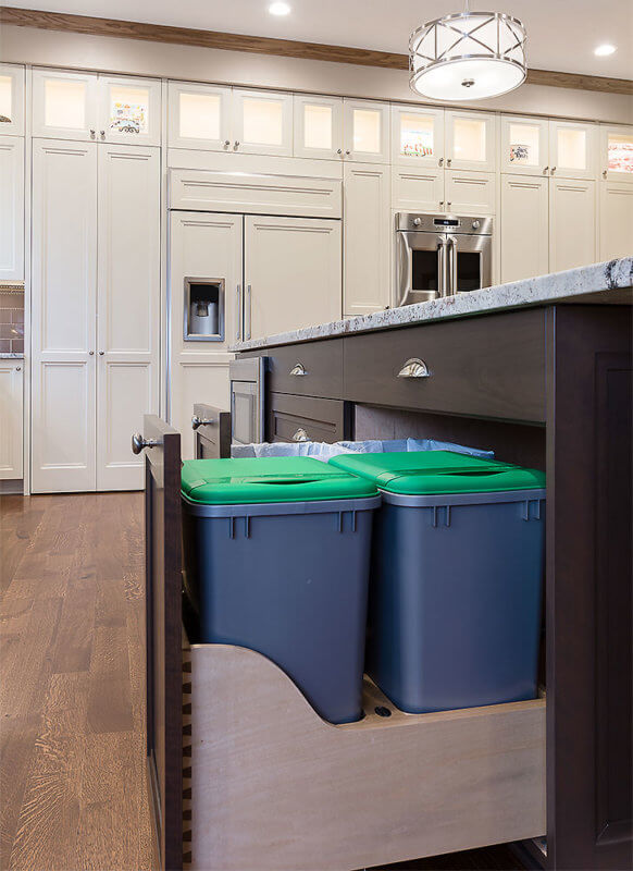 Large center island in Clive, Iowa kitchen remodel by Silent Rivers features pullouts for garbage and recycling