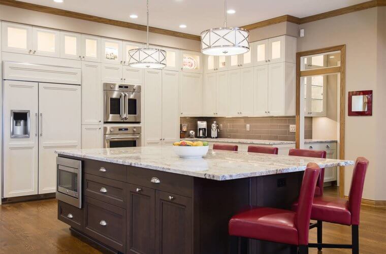 kitchens for large families_Large kitchen remodel in Clive, Iowa features large center island with seating for six, custom white and dark cabinets, french door oven, lighted upper display cabinets by remodeler Silent Rivers of Des Moines
