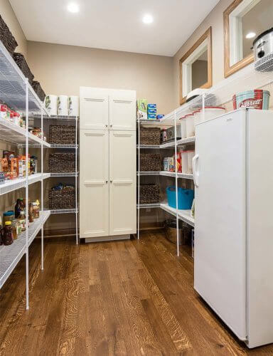 large walk-in pantry in Clive, Iowa kitchen remodel by Silent Rivers with shelves, extra refrigerator and transom windows for extra light