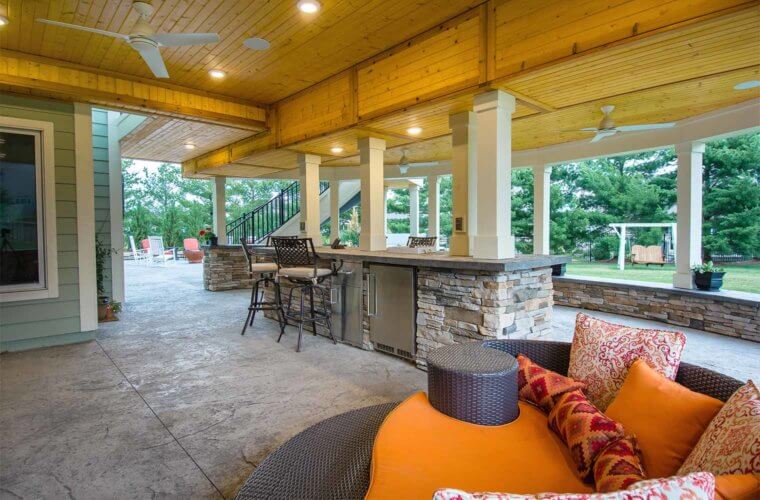 outdoor covered patio and bar area with wood plank ceiling, ceiling fan and curvy orange sofa