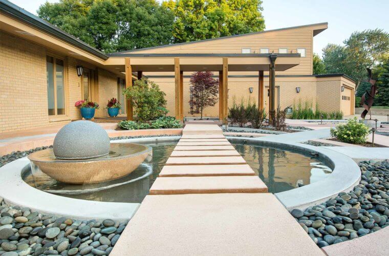 contemporary front entry courtyard with spherical water fountain with floating stepping stones in Johnston, Iowa by Silent Rivers