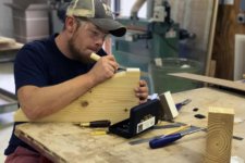 Alex Schlepphorst woodworker artisan hand carves wood corbel in Silent Rivers woodshop