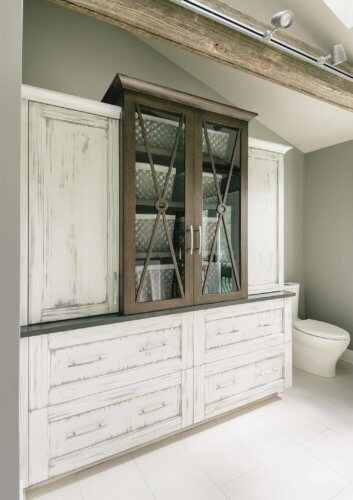 custom white distressed cabinet in master bathroom holds towels and toiletries and looks like a piece of furniture in master suiteglass enclosed centralized hexagonal shower in bathroom remodel by Silent Rivers of Des Moines