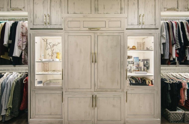 white distressed custom cabinet with lighted jewelry display cabinets in giant walk-in closet in master suite remodel by Silent Rivers of Des Moines