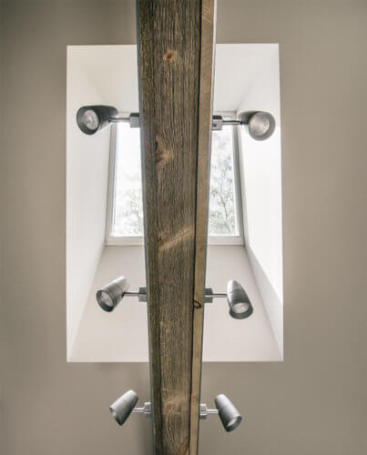 wooden ceiling beam under mechanical skylight holds lighting for bathroom remodel by Silent Rivers of Des Moines