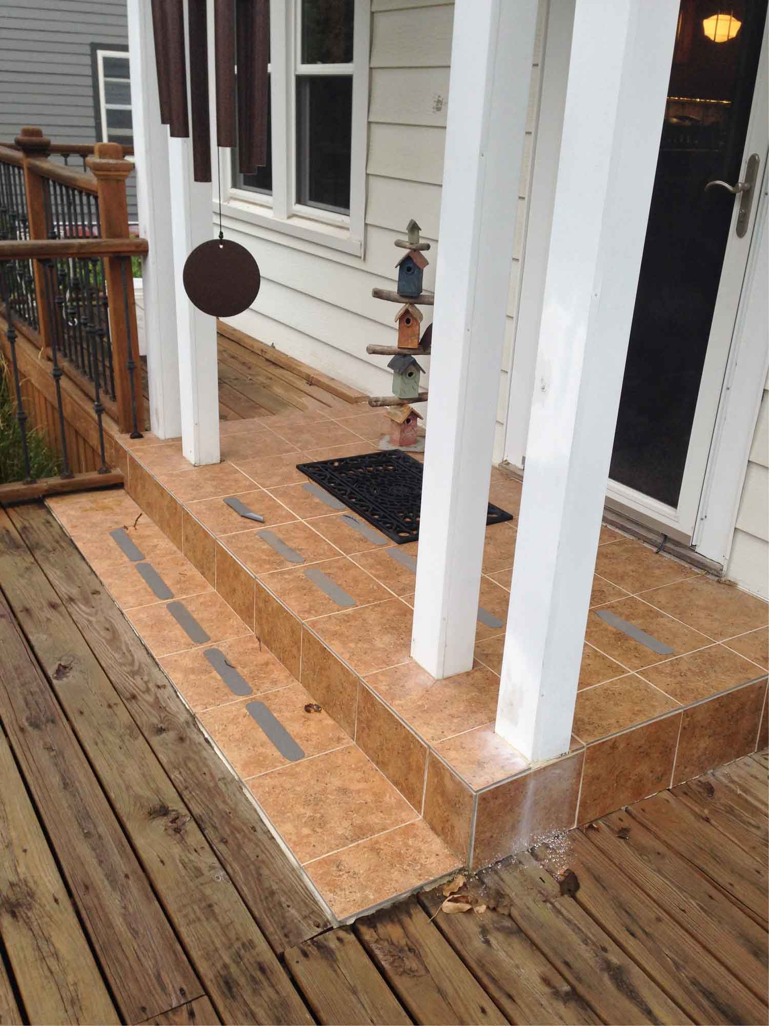 awkward tile steps on front porch of Des Moines home surrounded by cracking deck