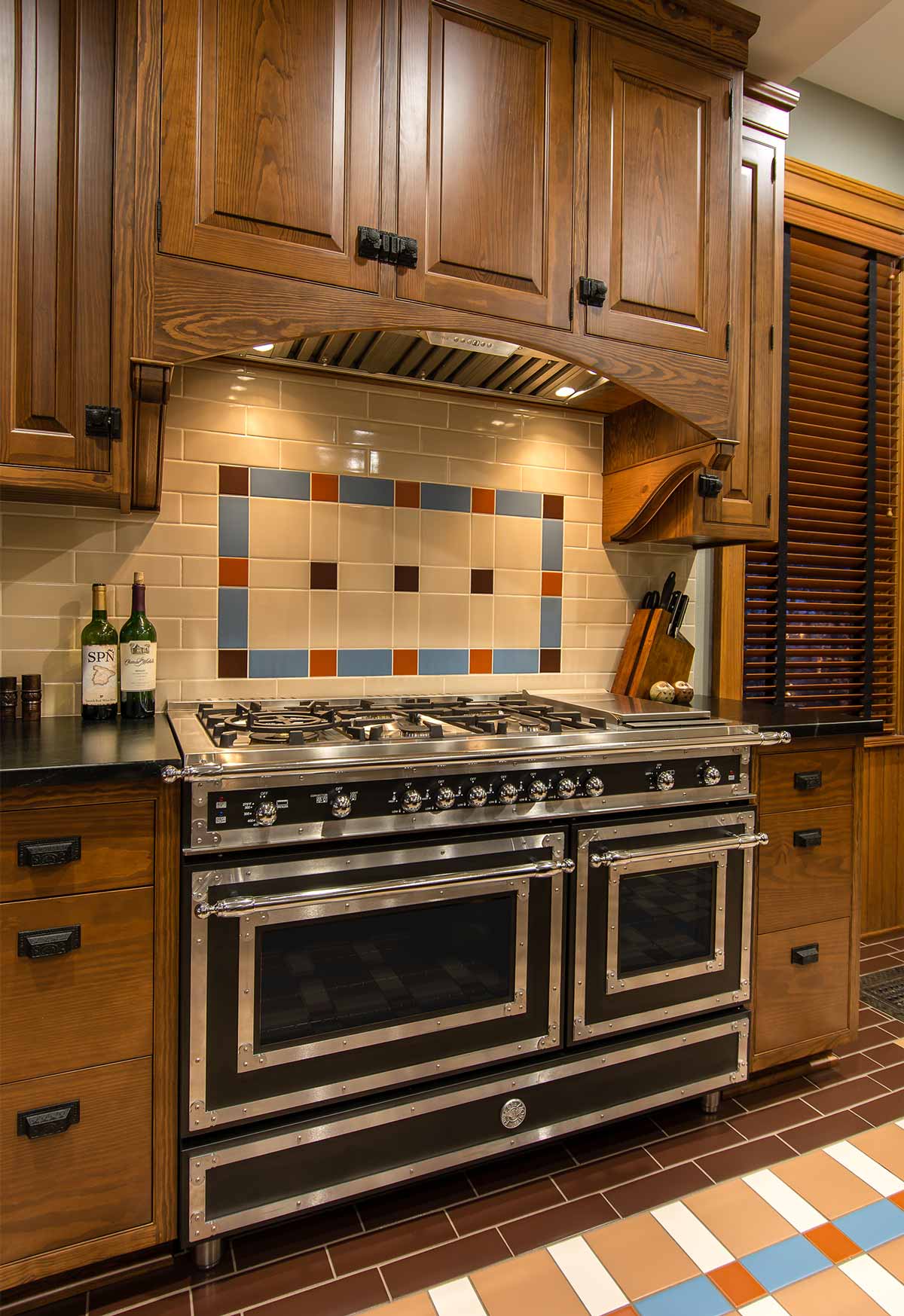 victorian looking modern stove range in a kitchen remodel by Silent Rivers in a historic Des Moines home with patterned tile backsplash and floor