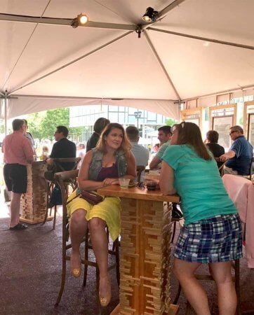 Inside the Silent Rivers VIP Club at Des Moines Arts Festival, patrons mingle near the bar