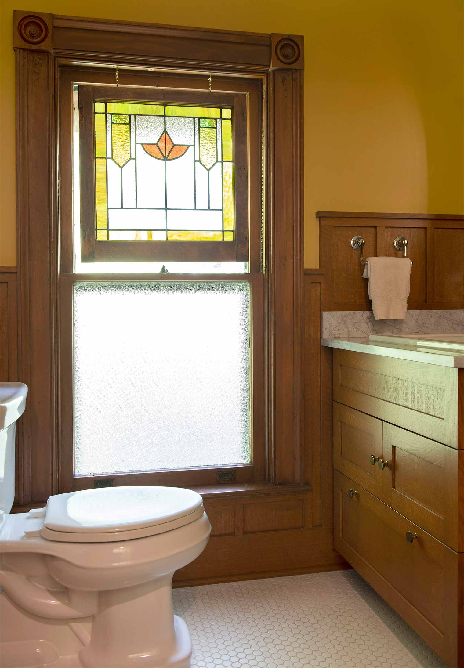 bathroom remodel in a Des Moines Victorian home renovation by Silent Rivers features stained glass window