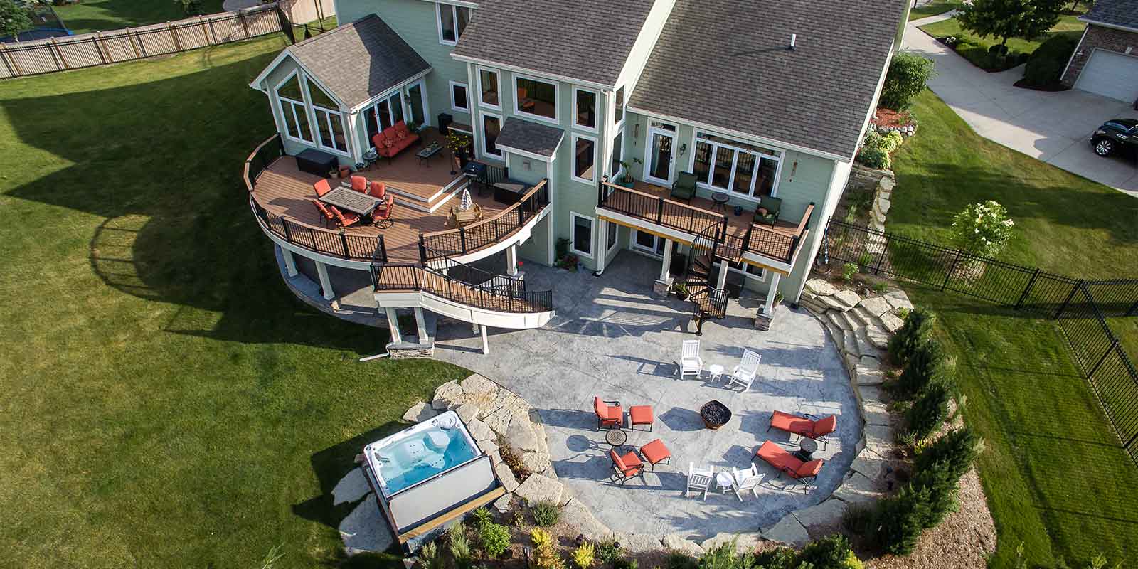 curved deck, patio, stairs, spa for resort style backyard by Silent Rivers of Des Moines