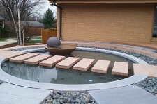 Water feature with stepping stones and a water bowl fountain at a Johnston, Iowa home