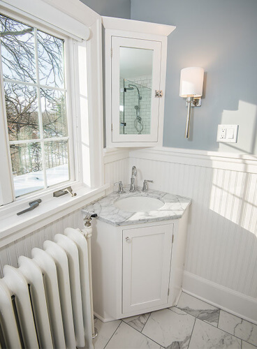 Des Moines, Iowa craftsman bathroom remodel by Silent Rivers with custom corner vanity and medicine cabinet to utilize small space