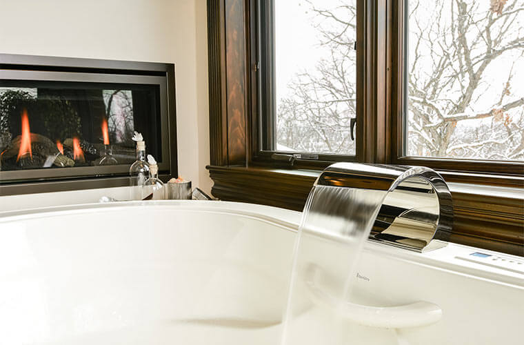 Urbandale-Iowa-luxurious-traditional-master-bathroom-by-Silent-Rivers with soaking tub,oversized waterfall tub filler and fireplace