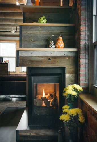 gas fireplace with barn board, raw steel, birch shelves in downtown Des Moines loft by Silent Rivers Design+Build