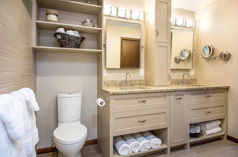 Double vanity custom designed includes lower open shelf and upper tall medicine cabinet in 1980s bathroom remodel by Silent Rivers, Des Moines