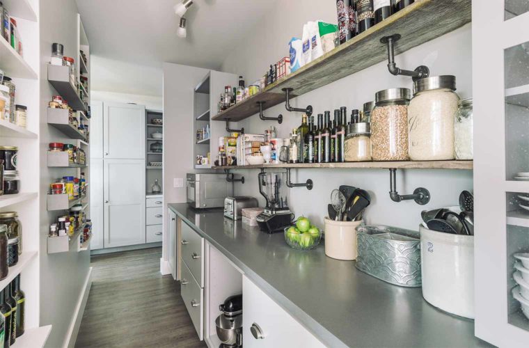 Walk through pantry with open shelving is located directly behind kitchen in barn style custom new home in rural St. Charles, Iowa designed and built by Silent Rivers of Des Moines