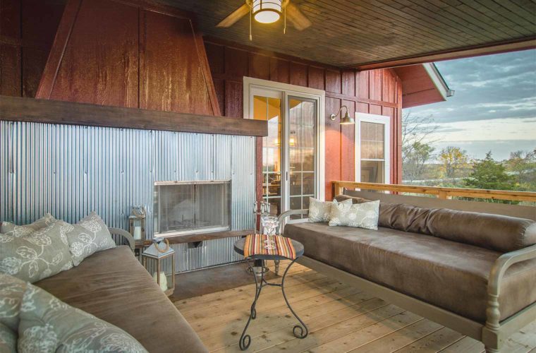 Barn style industrial farmhouse style custom new home in St. Charles, Iowa designed and built by Silent Rivers features an upper deck with steel surround fireplace