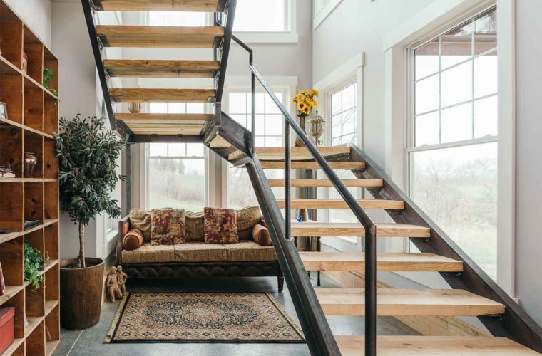 industrial farmhouse style custom new home in St. Charles, Iowa designed and built by Silent Rivers features a grand staircase made of steel channel and bridge plank lumber