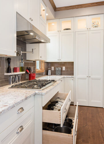 Transitional kitchen remodel in Clive, Iowa features drawers beneath the range for storing pots and pans by remodeler Silent Rivers