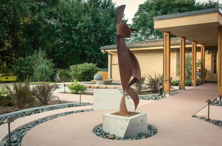 contemporary front entry courtyard with concentric circles design, metal sculpture, spherical water fountain in Johnston, Iowa by Silent Rivers