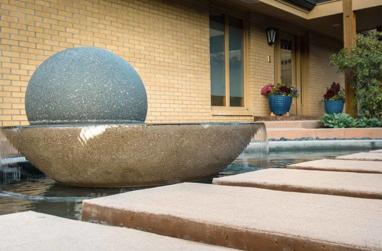 contemporary front entry courtyard with spherical water fountain with floating stepping stones in Johnston, Iowa by Silent Rivers