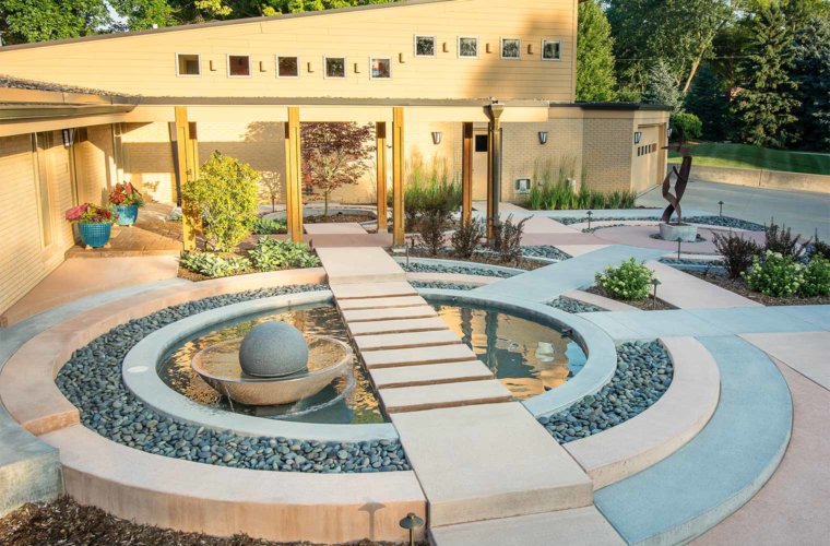 contemporary front entry courtyard with concentric circles, metal sculpture, spherical water fountain with floating stepping stones in Johnston, Iowa by Silent Rivers