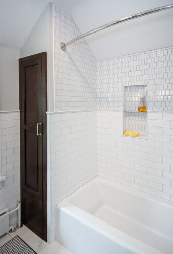custom storage tower closet beside white tile shower in Des Moines bathroom by remodeler Silent Rivers