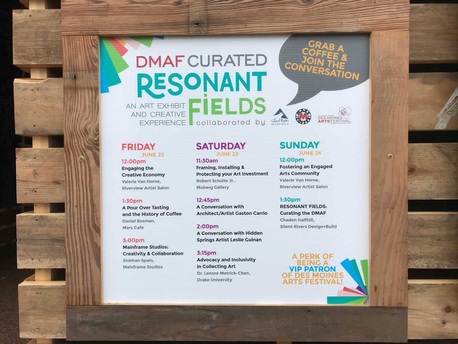 Schedule sign for DMAF Curated exhibit and presentations in the Creative Cafe area of the Silent Rivers VIP Club at the 2018 Des Moines Arts Festival