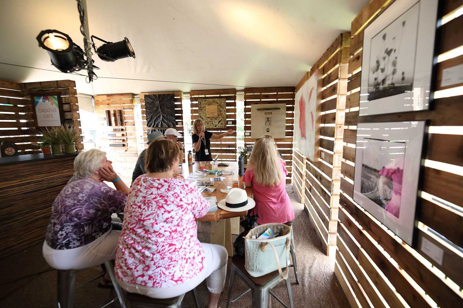 Leslie Ann Guinean, Hidden Springs artist, DMAF Curated exhibit and presentations in the Creative Cafe area of the Silent Rivers VIP Club at the 2018 Des Moines Arts Festival